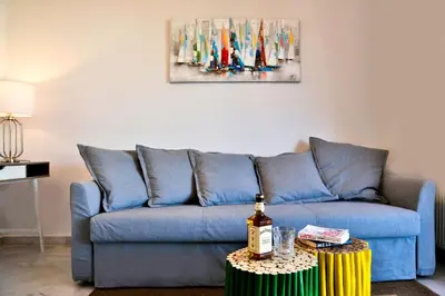 a blue couch in a living room with a painting on the wall at Boutique52 Luxury Apartments in Athens