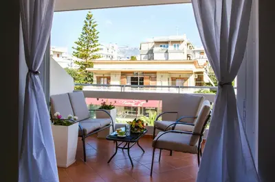 a balcony with chairs and a table and a large window at Boutique52 Luxury Apartments in Athens