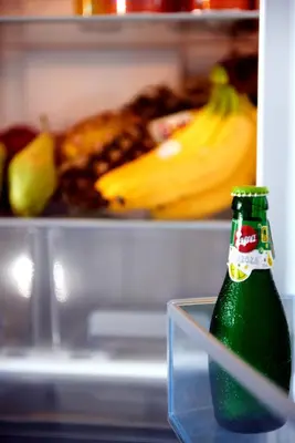 a bottle of soda in front of an open refrigerator at Boutique52 Luxury Apartments in Athens
