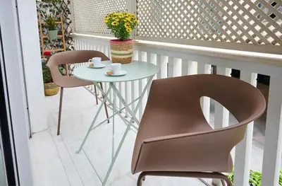 a small table and two chairs on a balcony at Rastoni Athens Suites near Acropolis in Athens