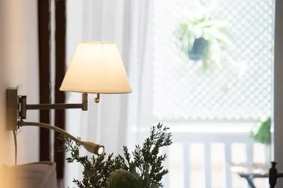 a lamp sitting next to a plant next to a window at Rastoni Athens Suites near Acropolis in Athens