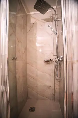 a shower with a glass door in a bathroom at Rastoni Athens Suites near Acropolis in Athens