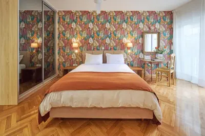 a bedroom with a large bed with a floral wallpaper at Rastoni Athens Suites near Acropolis in Athens