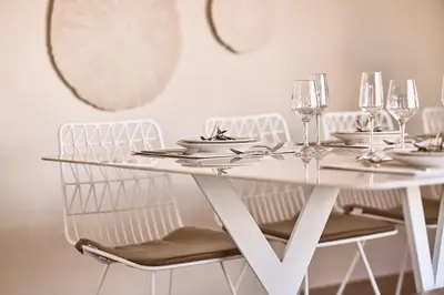 a white dining table with chairs and wine glasses at Grystal Green Properites in Athens