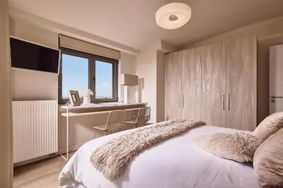 a bedroom with a bed with a desk and a window at Grystal Green Properites in Athens