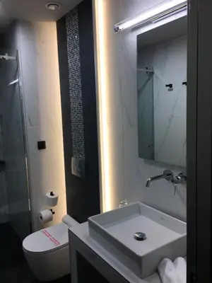 a bathroom with a sink and a toilet and a mirror at 360Degrees Pop Art Hotel in Athens