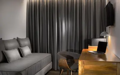 a living room with a couch and a desk with a laptop at 360Degrees Pop Art Hotel in Athens