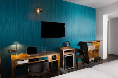 a hotel room with a desk and a television on the wall at 360Degrees Pop Art Hotel in Athens