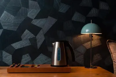 a tea kettle on a table next to a lamp at 360Degrees Pop Art Hotel in Athens