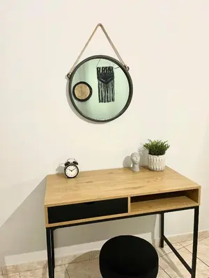 a mirror hanging on a wall above a desk at Anastasias house near Athens airport in Spáta
