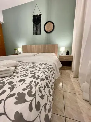 a bedroom with a bed and a clock on the wall at Anastasias house near Athens airport in Spáta