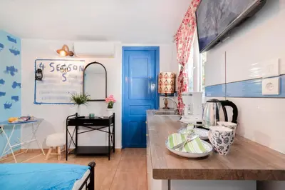 a kitchen with blue and white walls and a blue door at 4 Seasons Suites Paradise Near Airport And Beach in Markopoulo