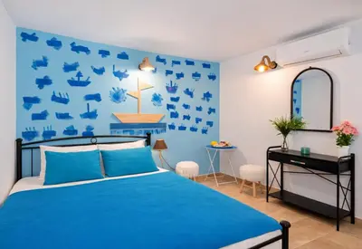 a blue bedroom with a bed and a desk at 4 Seasons Suites Paradise Near Airport And Beach in Markopoulo