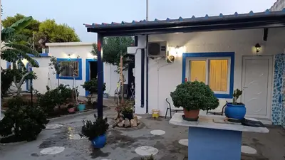 a house with potted plants in front of it at 4 Seasons Suites Paradise Near Airport And Beach in Markopoulo