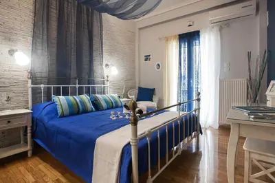 a bedroom with a bed with a blue comforter at Elegant and Safe Gold and Blue Apartment walk to Acropolis in Athens