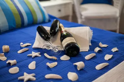 a bottle of wine and shells on a bed at Elegant and Safe Gold and Blue Apartment walk to Acropolis in Athens