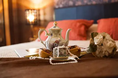 a table with a tea pot on top of a bed at Elegant and Safe Gold and Blue Apartment walk to Acropolis in Athens