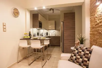 a kitchen and living room with a table and chairs at Elegant and Safe Gold and Blue Apartment walk to Acropolis in Athens