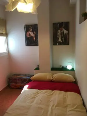 a bed in a bedroom with two pictures on the wall at Biophylic - 3bdr apartment in Athens