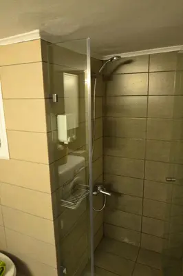 a shower with a glass door in a bathroom at Biophylic - 3bdr apartment in Athens