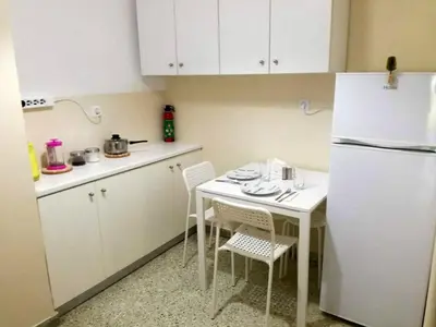 a kitchen with a white refrigerator and a table and chairs at Biophylic - 3bdr apartment in Athens