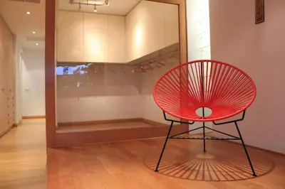 a red chair sitting in front of a closet at 5* 