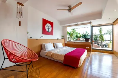 a bedroom with a bed and a red chair at 5* 