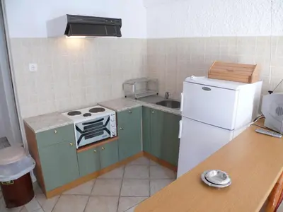 a kitchen with green cabinets and a white refrigerator at Esperides Maisonettes in Agia Marina Aegina