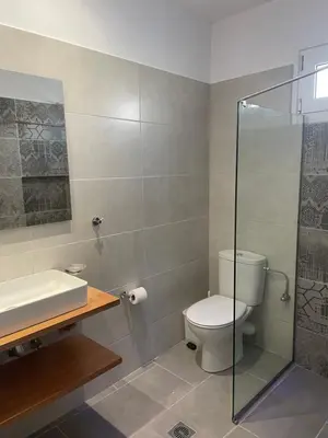 a bathroom with a toilet and a glass shower at Esperides Maisonettes in Agia Marina Aegina