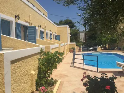 a house with a swimming pool next to a building at Esperides Maisonettes in Agia Marina Aegina