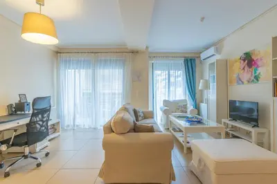 a living room with a couch a desk and a tv at Patissia Apartment in Athens