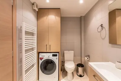 a bathroom with a toilet and a washing machine at Patissia Apartment in Athens