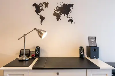 a desk with a lamp and a world map on the wall at Patissia Apartment in Athens
