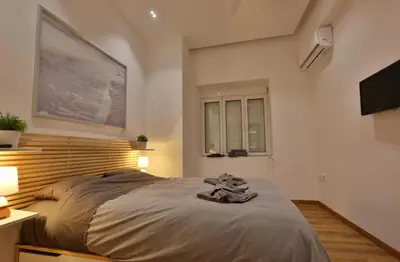 a bedroom with a large bed and a television at Luxury Apartment near Acropolis in Athens