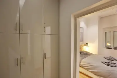 a bedroom with white cabinets and a bed with a mirror at Luxury Apartment near Acropolis in Athens