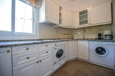 a kitchen with white cabinets and a washer and dryer at Starapartment Athens-Varkiza Top 1 in Varkiza