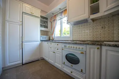 a kitchen with white cabinets and a white dishwasher at Starapartment Athens-Varkiza Top 1 in Varkiza