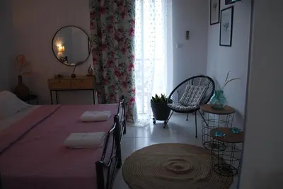 a bedroom with a bed with a table and a mirror at Sunset Rooms in Agia Marina Aegina