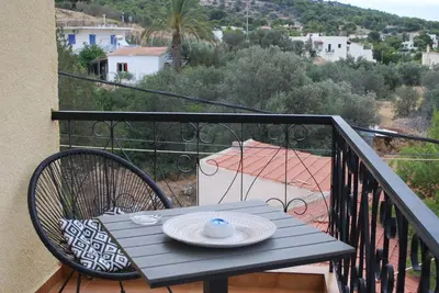 a blue table and chairs on a balcony at Sunset Rooms in Agia Marina Aegina
