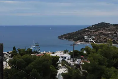 a view of a city and the ocean from a hill at Sunset Rooms in Agia Marina Aegina