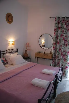 a bedroom with a large bed with two towels on it at Sunset Rooms in Agia Marina Aegina