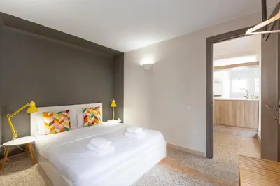 a bedroom with a large white bed and a mirror at Psirri Place economy apartments centrally located in Athens