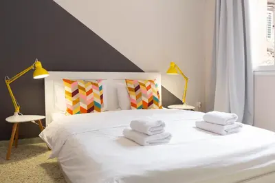 a bedroom with a white bed with towels on it at Psirri Place economy apartments centrally located in Athens