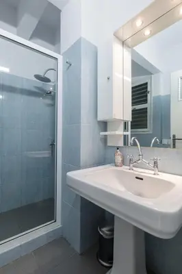 a white bathroom with a sink and a shower at Central 5 Room Apartment in Athens