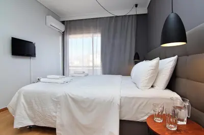 a bedroom with a large white bed and a window at Central Apartment in Athens