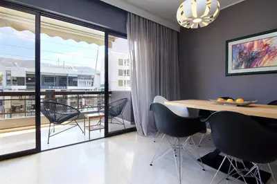 a dining room with a table and chairs and a balcony at Central Apartment in Athens