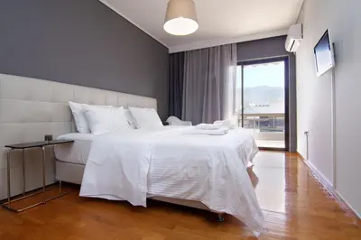 a bedroom with a large white bed and a window at Central Apartment in Athens