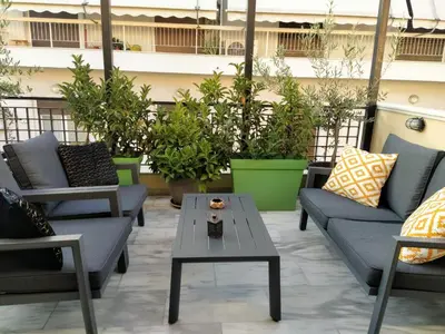 a patio with couches and a table and plants at Elia Apartments in Athens