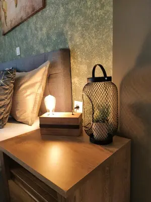 a bed with a table with a lamp on it at Elia Apartments in Athens
