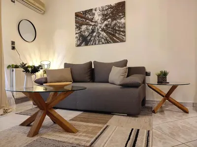 a living room with a couch and a glass table at Elia Apartments in Athens